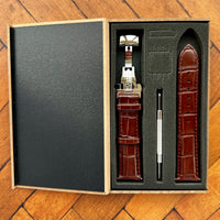 Thumbnail for Watch strap kit with brown leather strap, silver buckle, and tools in a box on a wooden surface.