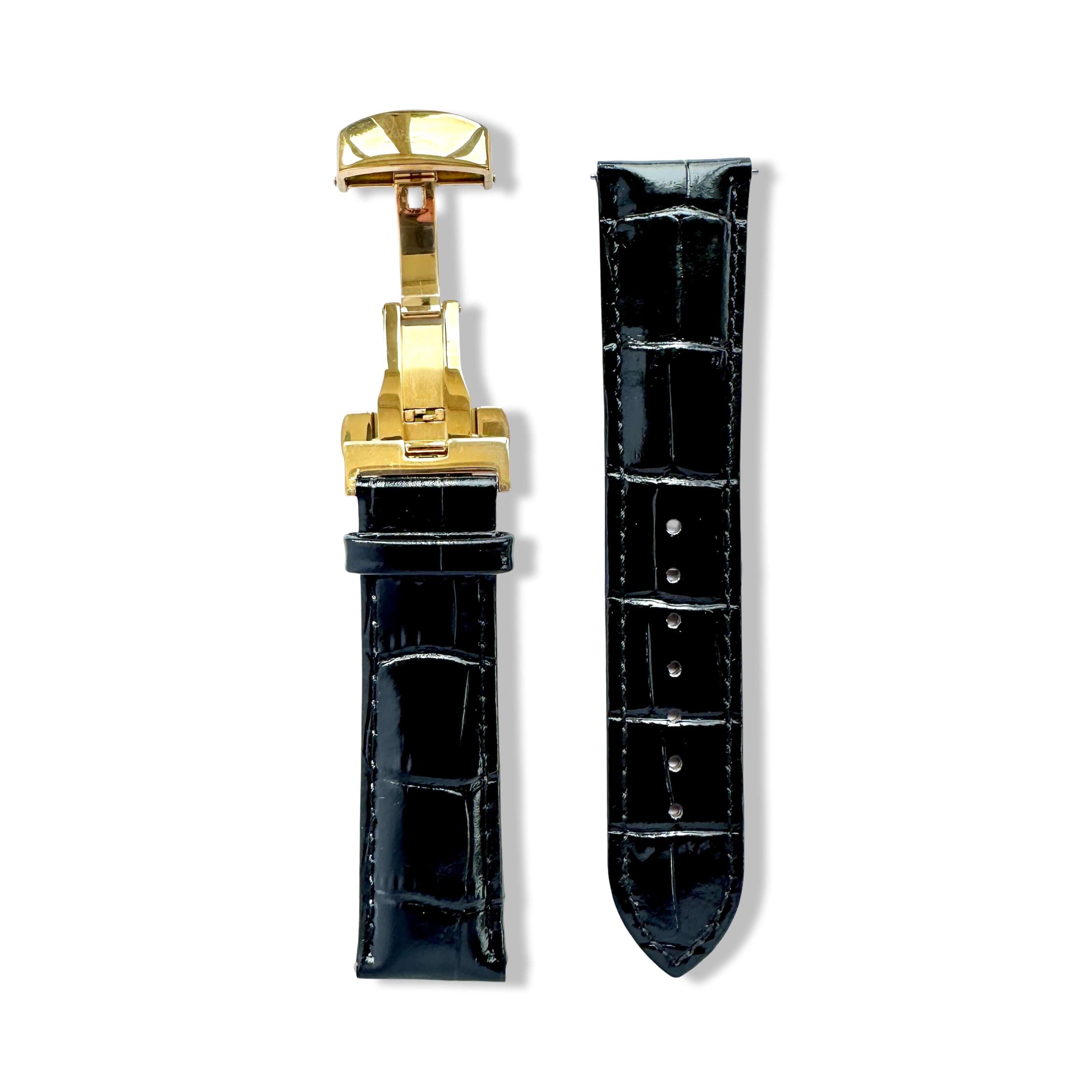 Black crocodile-patterned watch strap with gold clasp on a white background